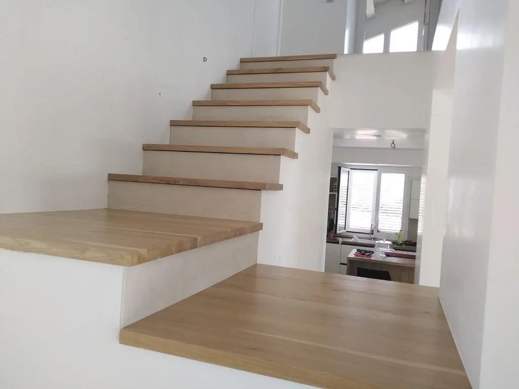 Palier et marches en chêne massif dans un escalier aux murs blancs