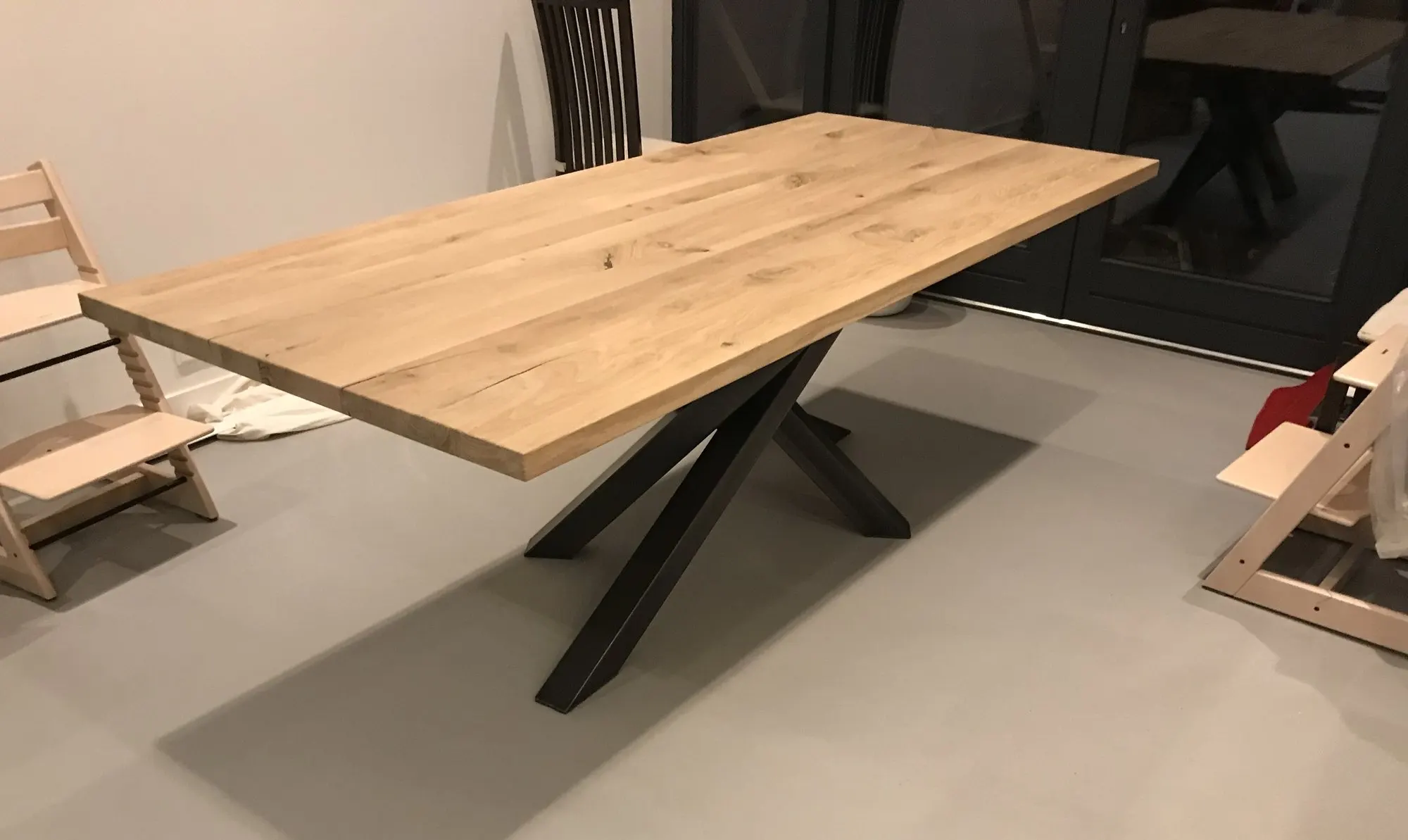 Plateau de table rectangulaire en chêne massif posé sur un piètement en acier noir